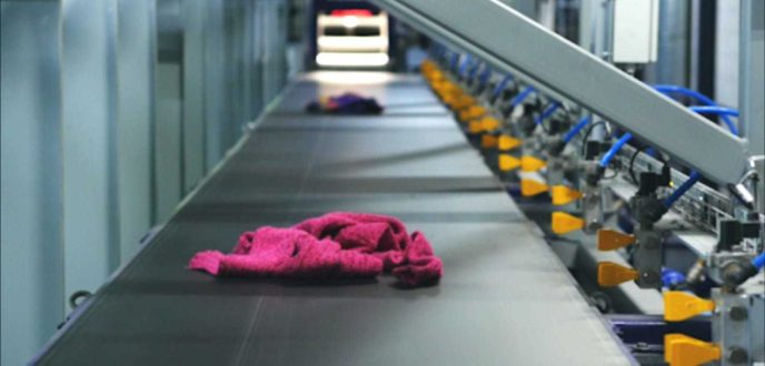 Fibersort machine die de kleding sorteert met een laser en via luchtdruk de kleding van de lopende band in de containers blaast