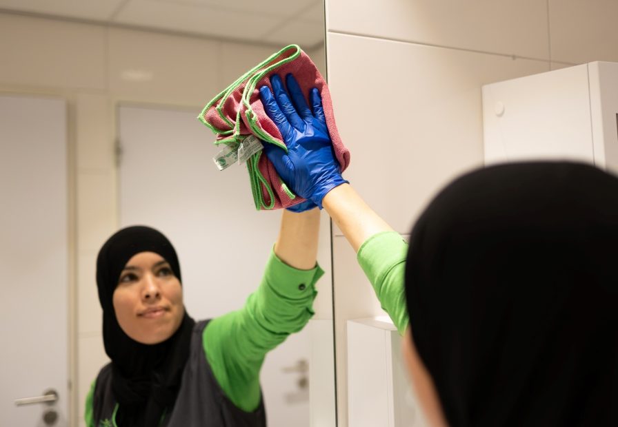 Vrouw met doek bij spiegel